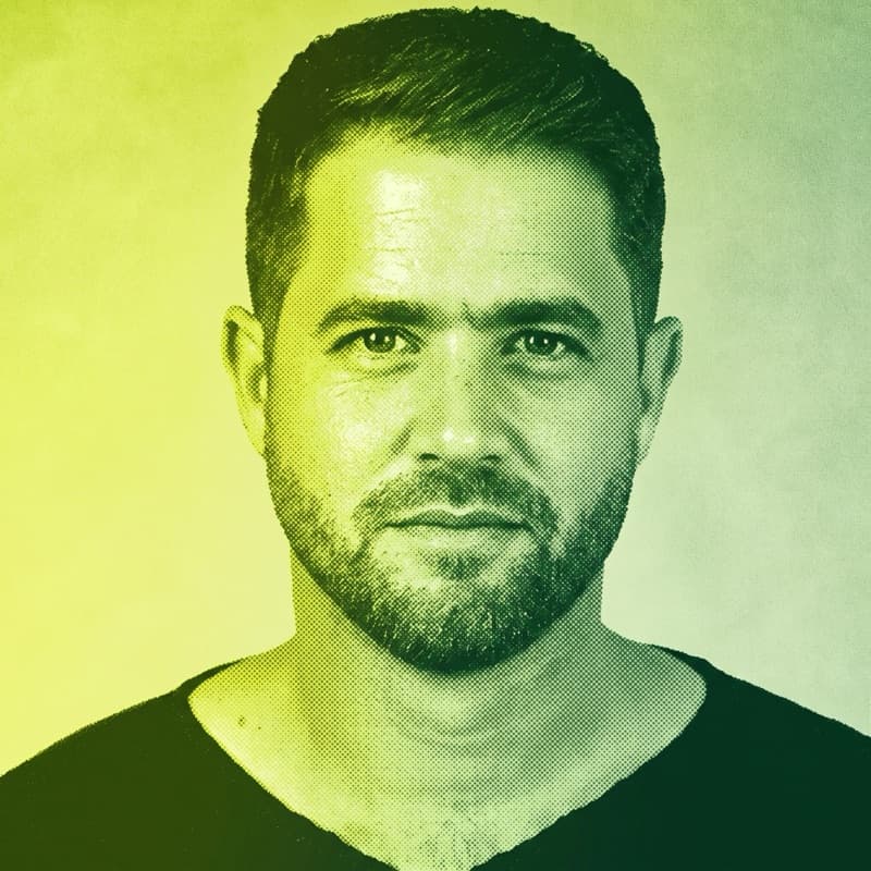 Duotone portrait of Tal Slavin, with short hair and a beard